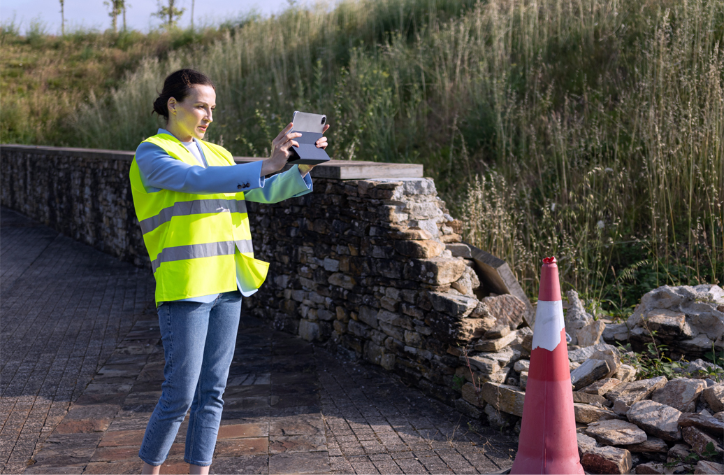 Claims Adjuster Reviewing Damage to Stone Wall